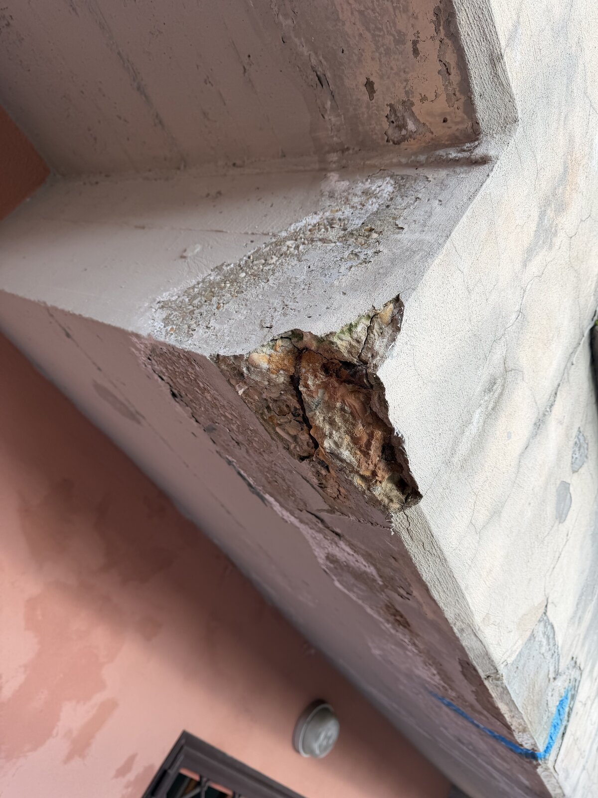 Spigolo di cornicione con calcestruzzo profondamente ammalorato e aggregato visibile