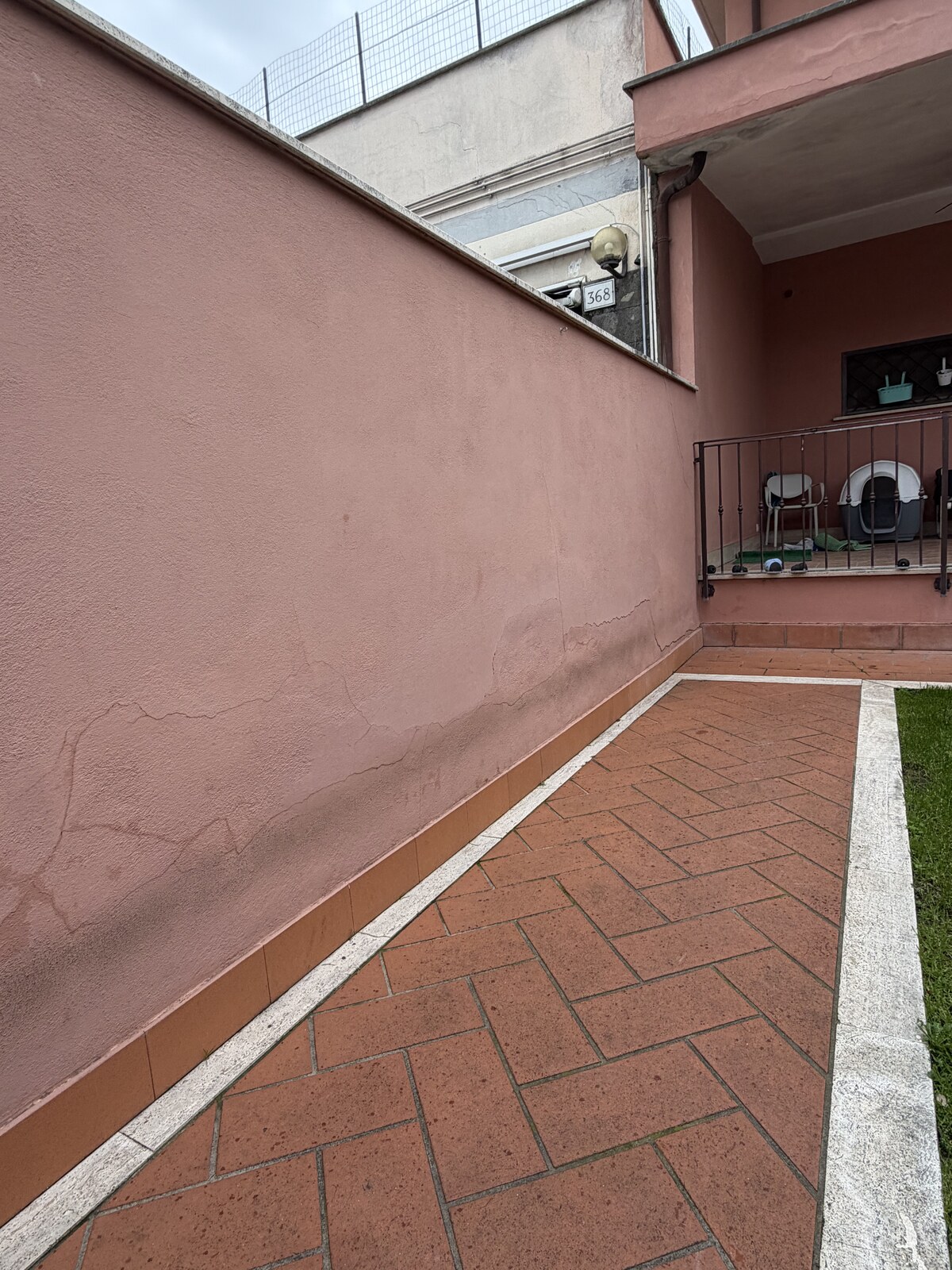 Muro perimetrale tinteggiato di rosa terracotta dopo intervento