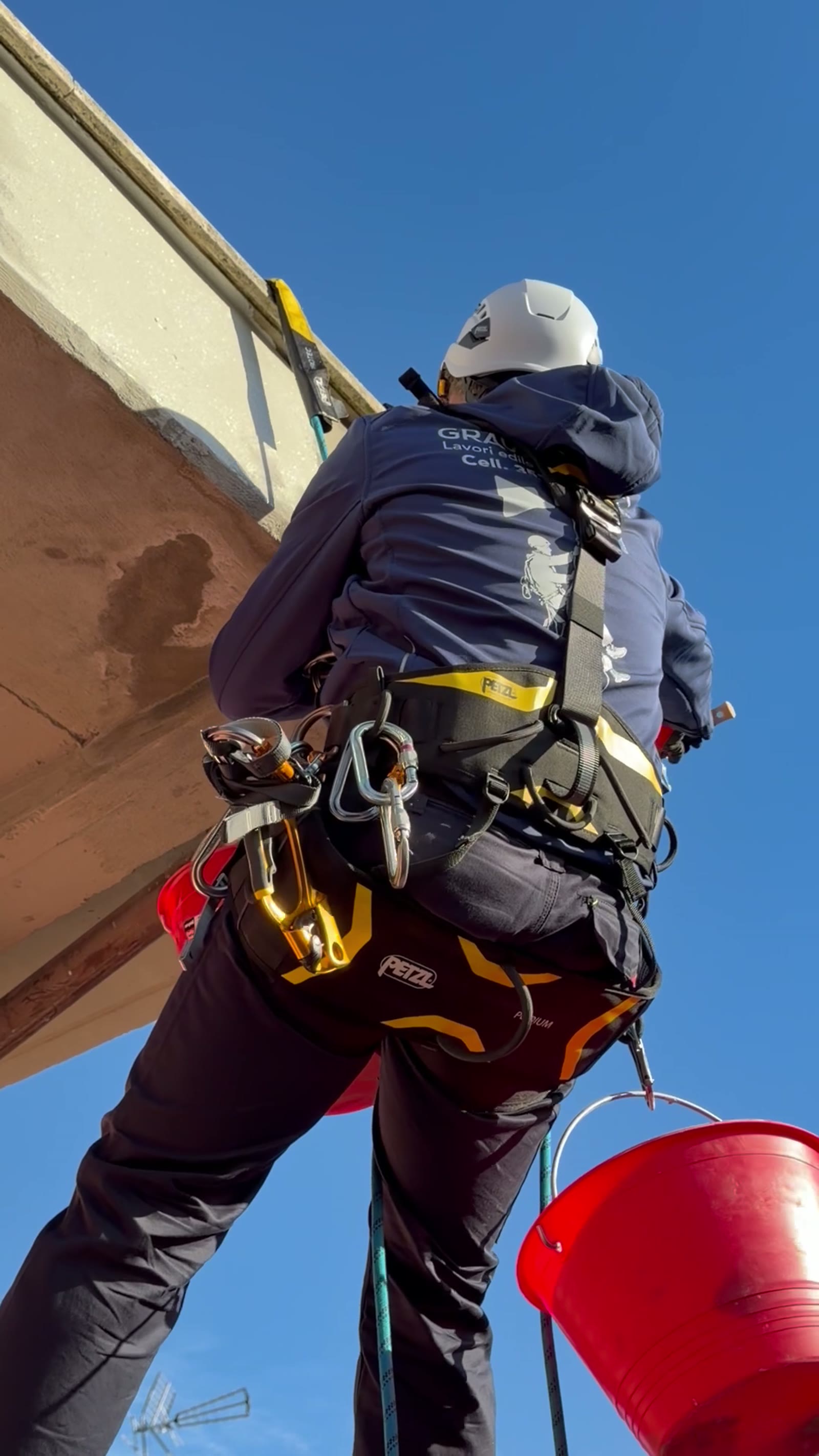 Operatore GraviTec su corda con imbragatura Petzl per intervento su cornicione