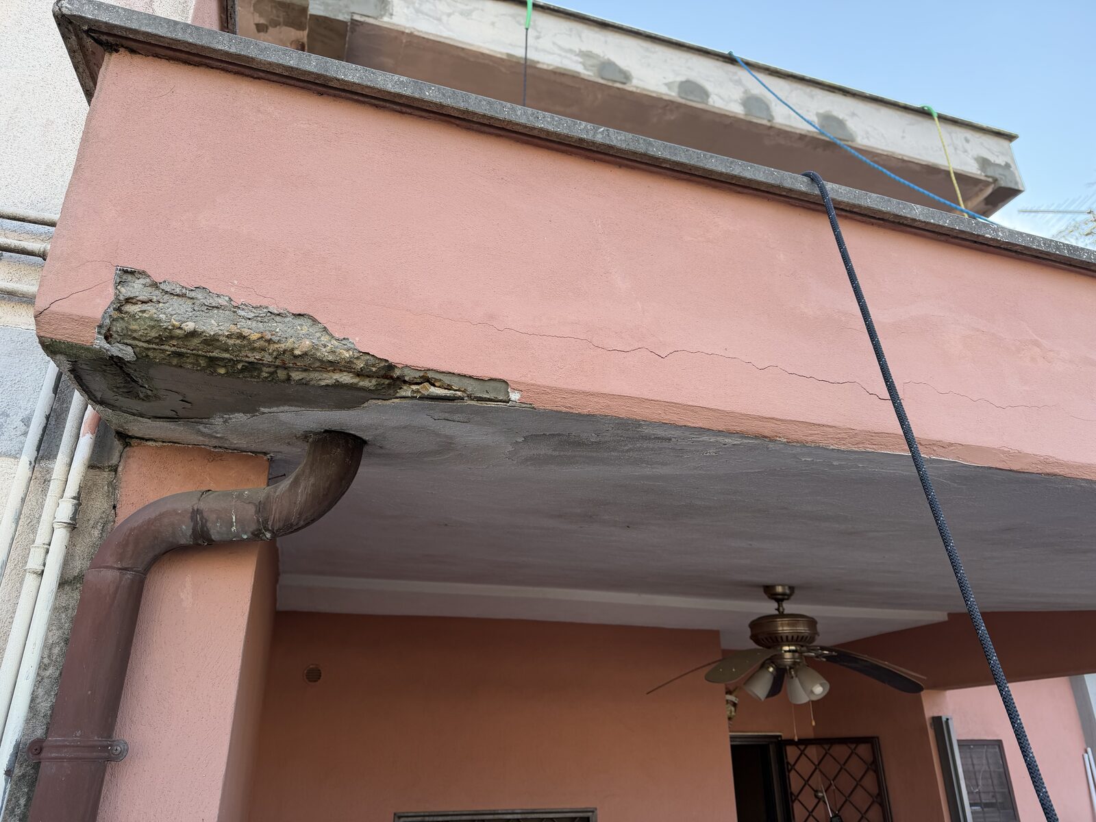 Angolo di balcone su villa rosa con copriferro espulso e cemento ammalorato